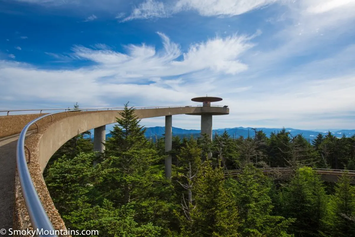An elevated observation deck overlooking sweeping mountain ranges and a bright blue sky. The tranquil setting invites quiet contemplation or group enjoyment of the breathtaking scenery, perfectly embodying the mountain vistas mentioned in the section.